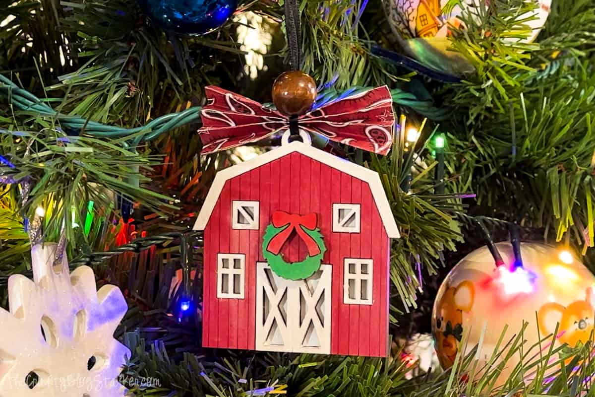DIY barn ornament hanging on a Christmas tree.