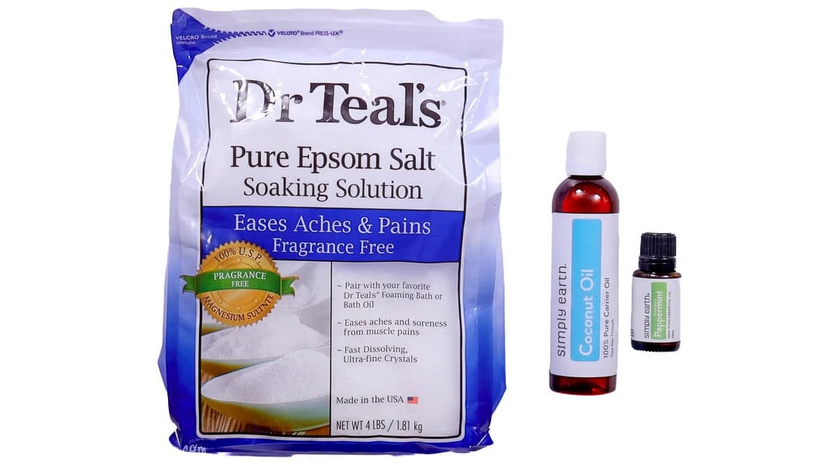 Ingredients for a homemade foot soak, including Dr Teal's Epsom salt, Simply Earth coconut oil, and peppermint essential oil.