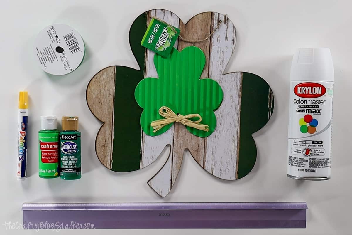 Supplies used: Shamrock cut-out, white spray paint, green acrylic paint, Green ribbon, steel ruler, and a yellow paint marker.