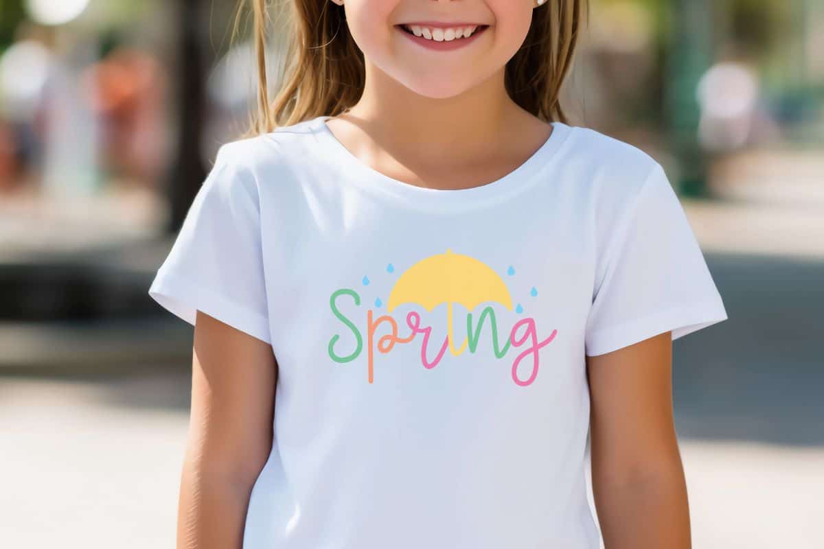 Girl wearing a white t-shirt with a spring showers svg design.