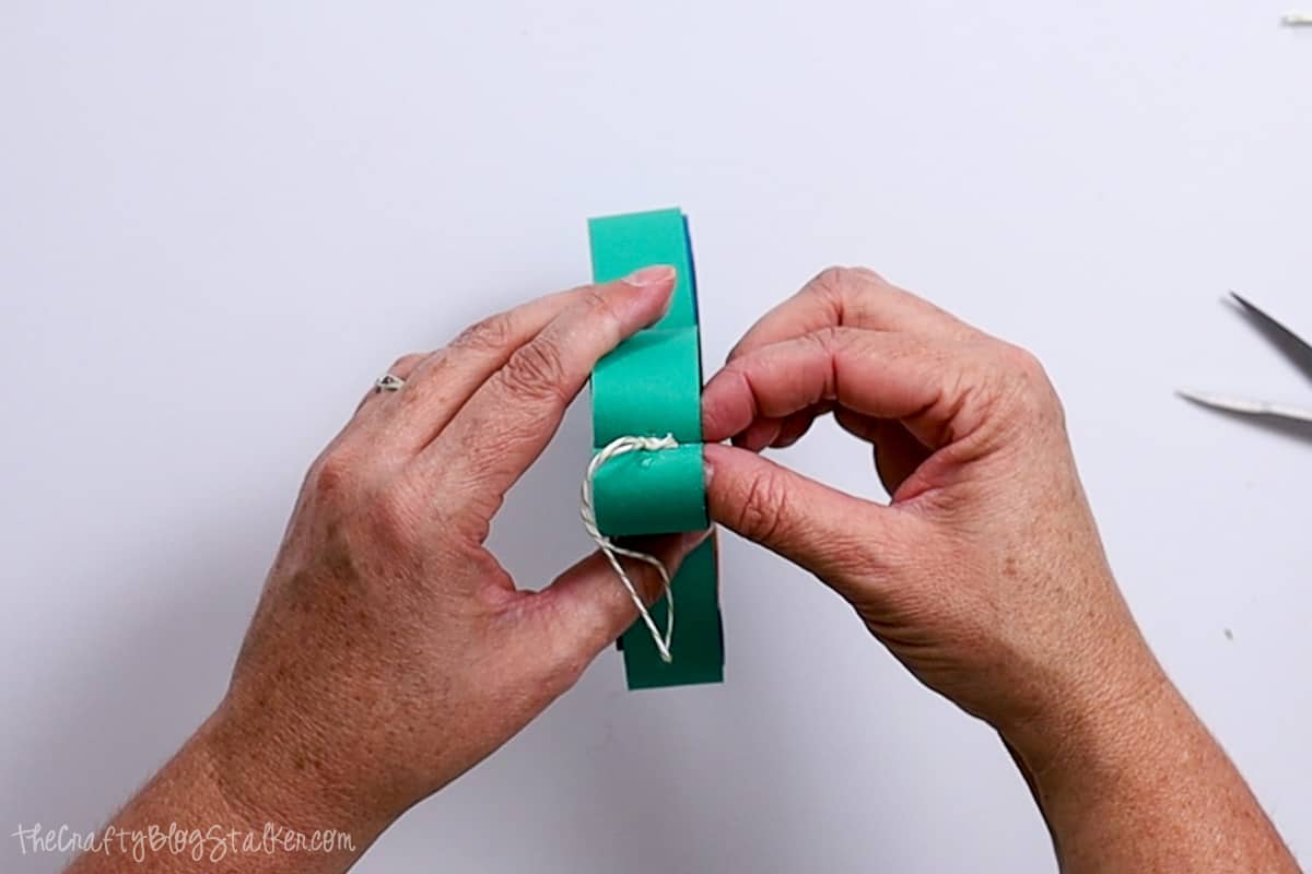 Adding a hanger to the paper shamrock.