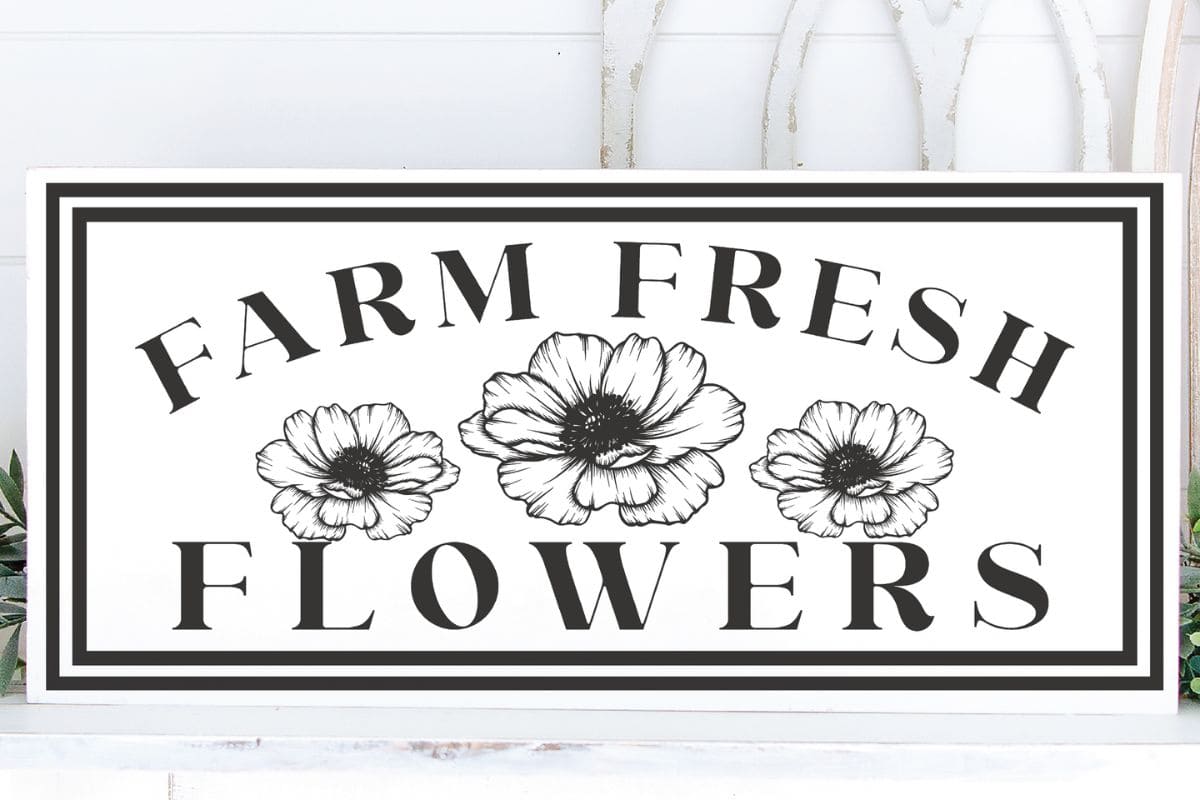 A white and black DIY sign that reads farm fresh flowers.