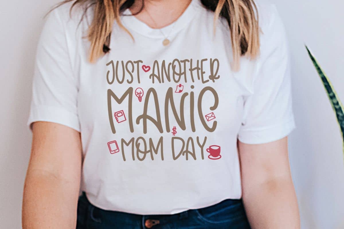 Woman wearing a shirt that reads just another manic mom day.