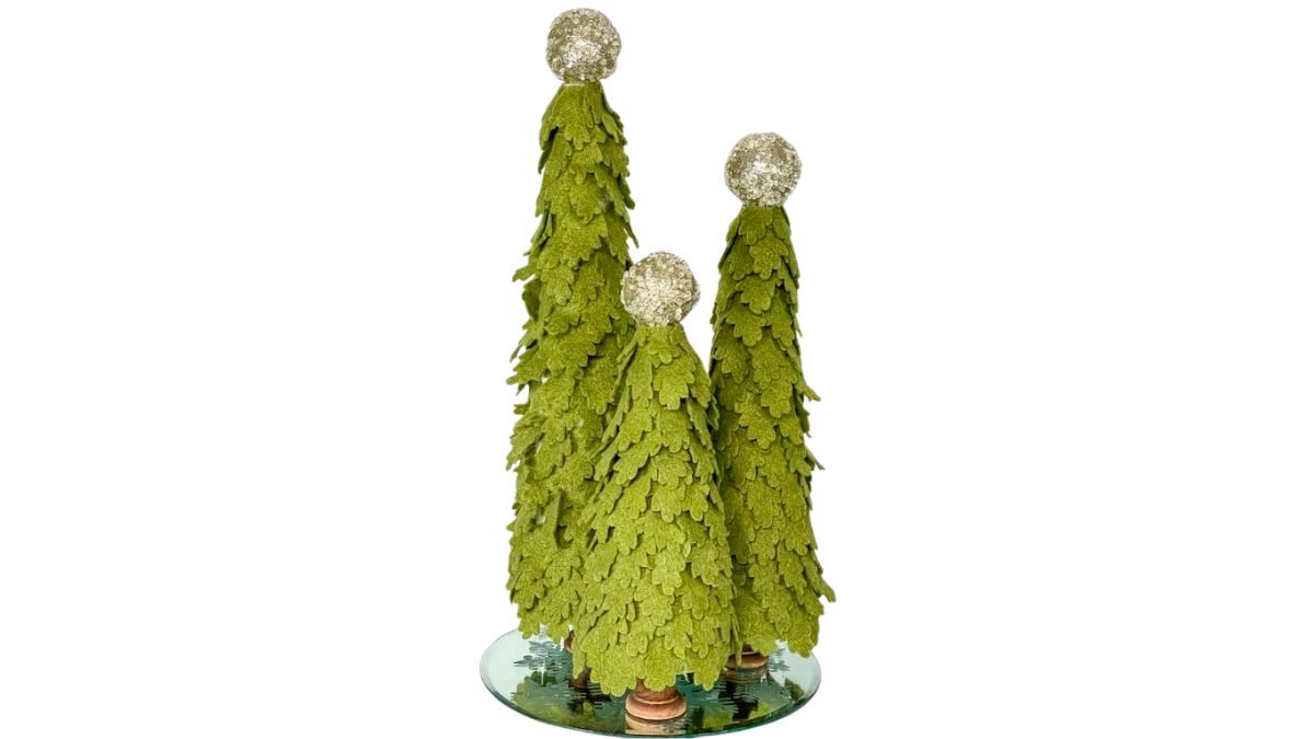 Three handmade felt Christmas trees topped with glittery balls, arranged on a mirrored base for festive holiday decor.