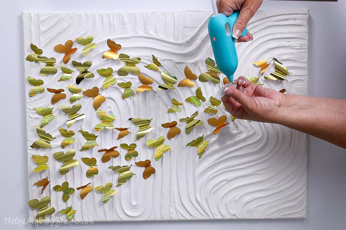 Applying hot glue to the folded butterfly.