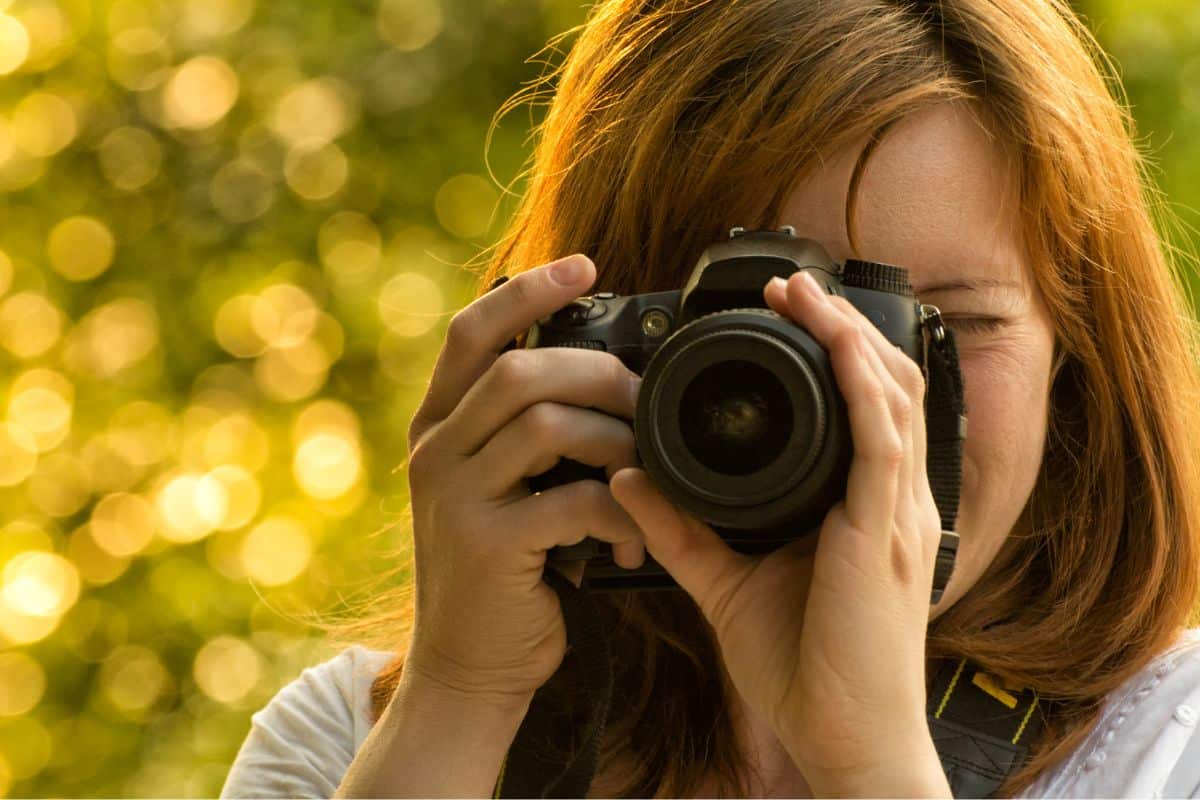 Woman taking a photograph with a camera.