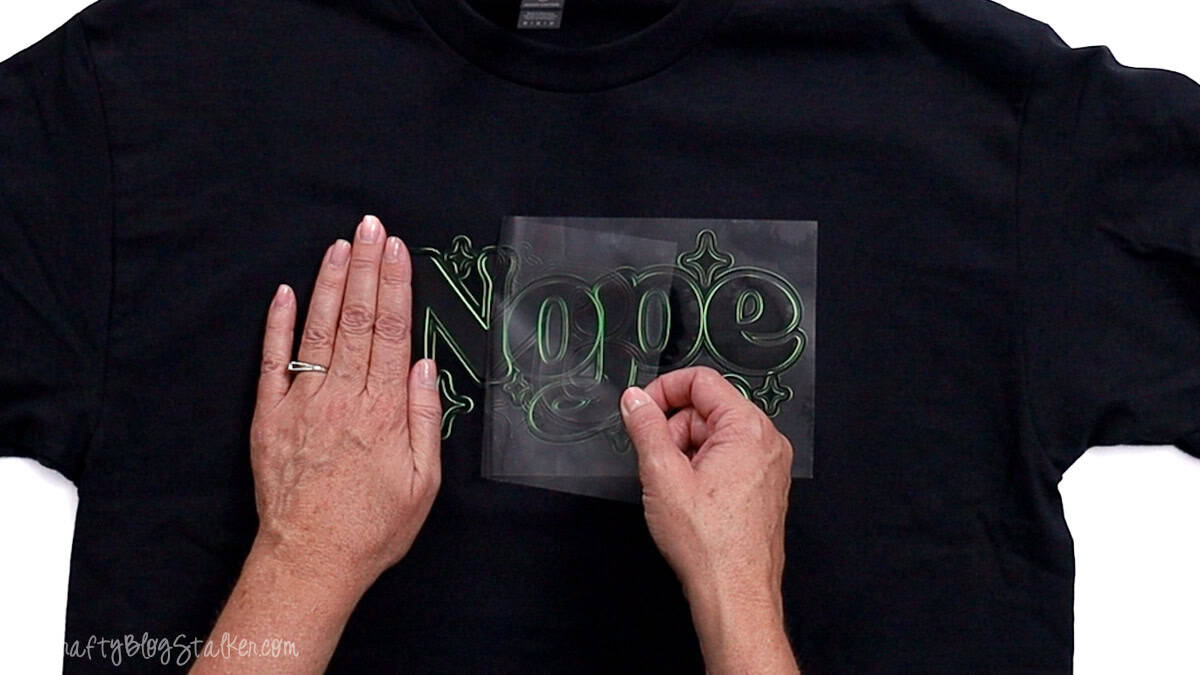 Hands peeling the clear carrier sheet off a freshly pressed