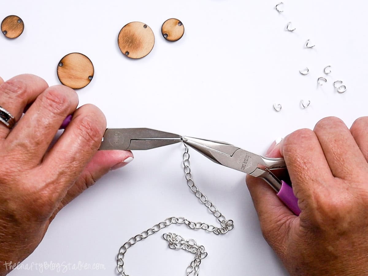 Opening links from a necklace with two pairs of pliers.