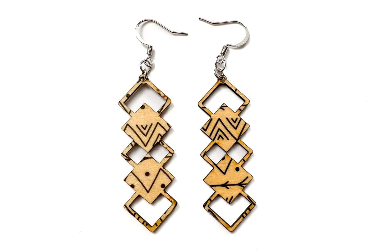 Assembles pair of wood earrings cut with a laser.