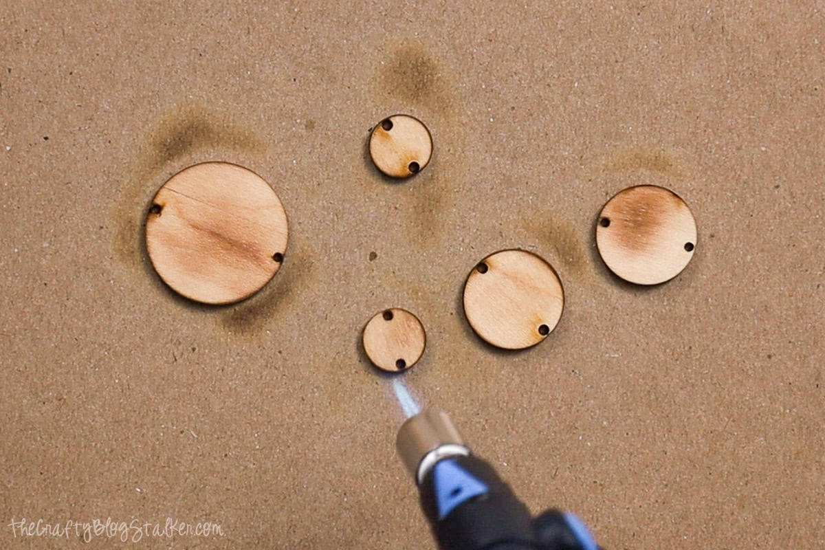 Adding burn marks to wood circles.