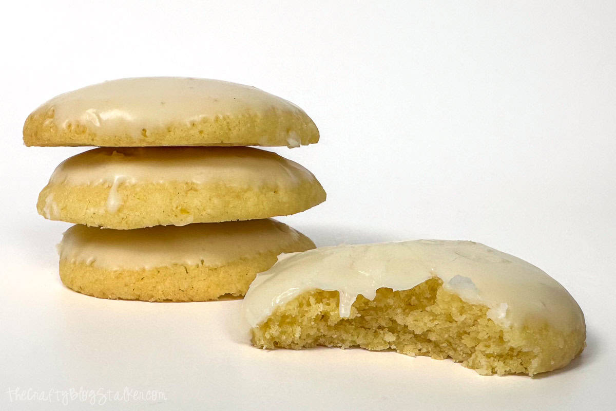 Four Lemon cookies with lemon icing, one cookie has a bit out of it.