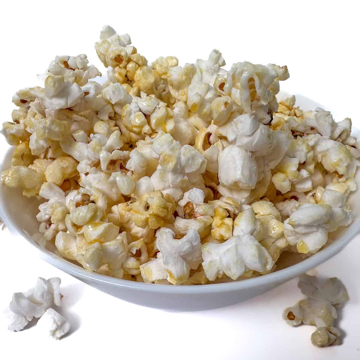 A close-up view of freshly made kettle corn in a white bowl, showcasing its sweet and salty coating with a light, crunchy texture-perfect for snacking anytime.