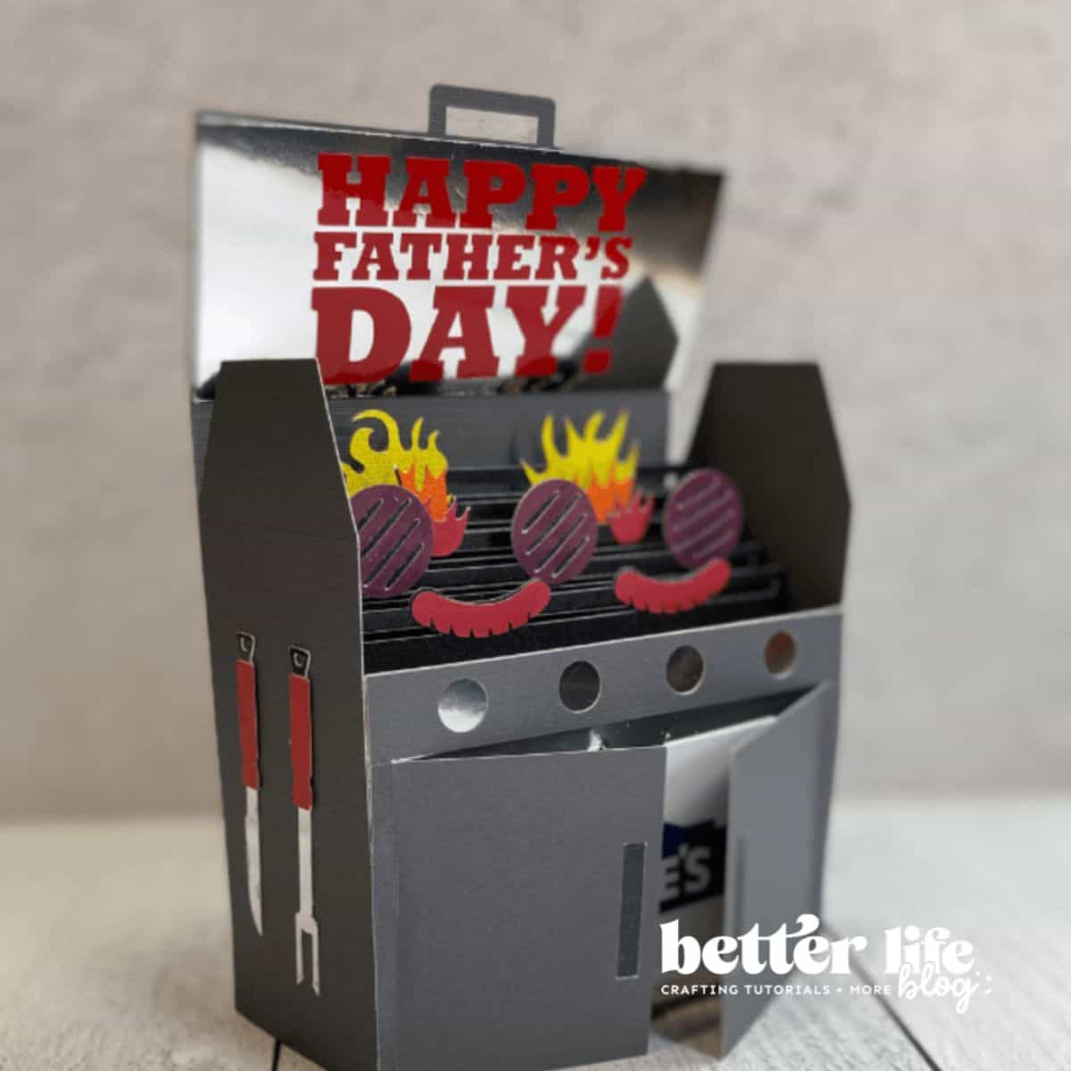 3D paper craft of a BBQ grill with burgers, flames, and utensils, featuring a pop-up “Happy Father’s Day!” message; created by Better Life Blog.