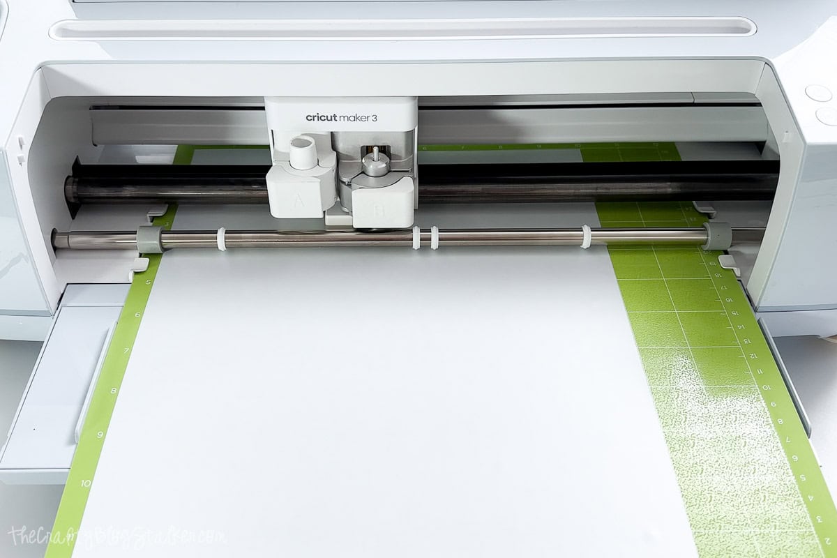 Cricut Maker 3 cutting white heat transfer vinyl on a green mat, preparing a design for a DIY Father's Day craft project.