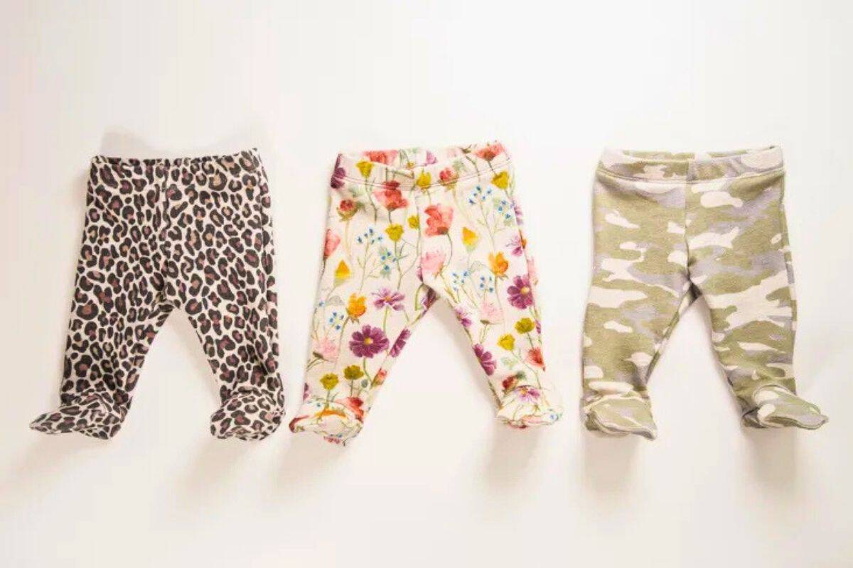 Three pairs of baby footed pants in leopard, floral, and camouflage prints displayed on a white background.