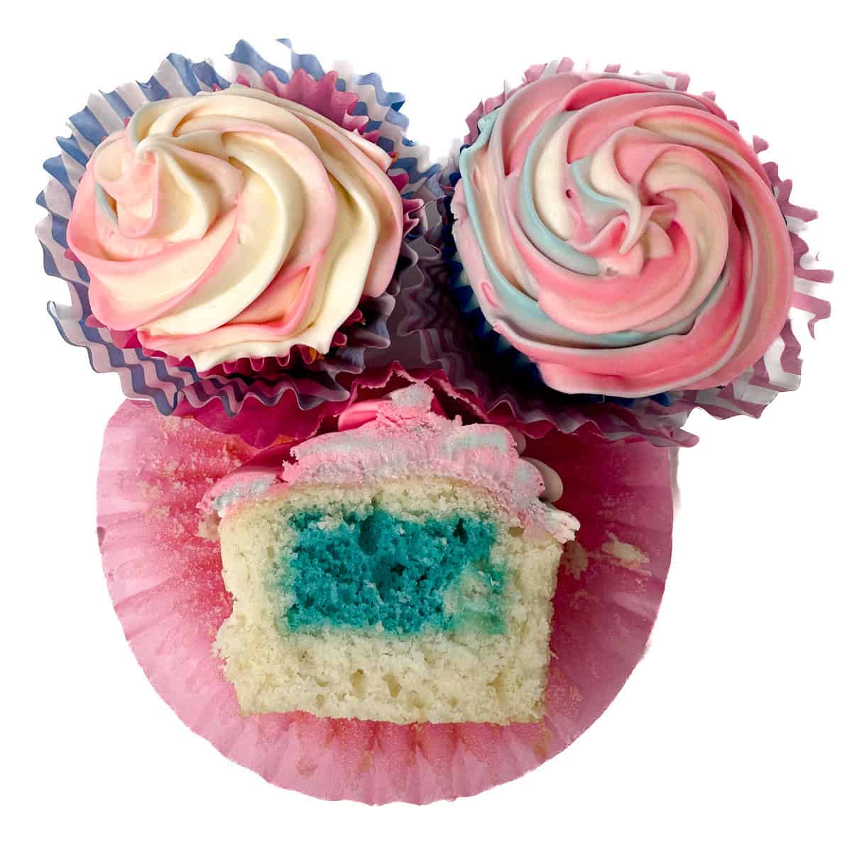 Three gender reveal cupcakes with swirled pink, blue, and white frosting; one is cut open to show a bright blue cake center.