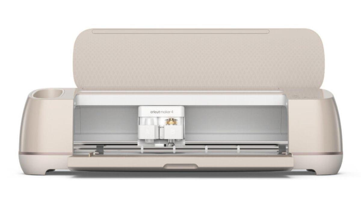 A beige Cricut Maker 4 cutting machine with its lid open, revealing the dual tool clamps and cutting area inside.