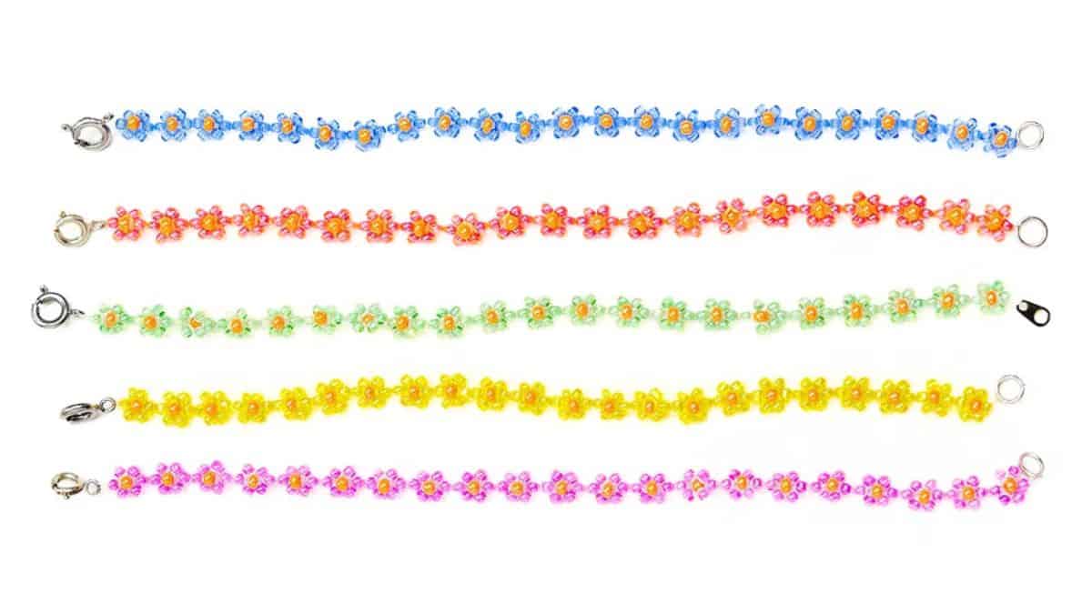 Five colorful beaded flower bracelets in blue, pink, green, yellow, and purple, each with tiny floral designs and metal clasps.