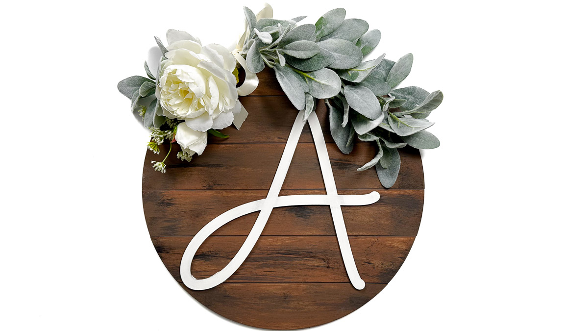 Round wooden door hanger with a large white letter