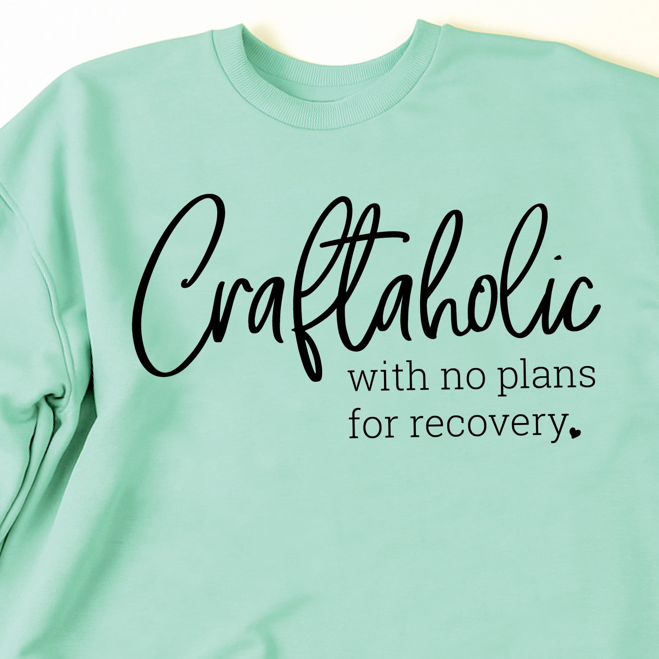 Crewneck sweatshirt laid flat with the phrase Craftaholic with no plans for recovery printed across the front.