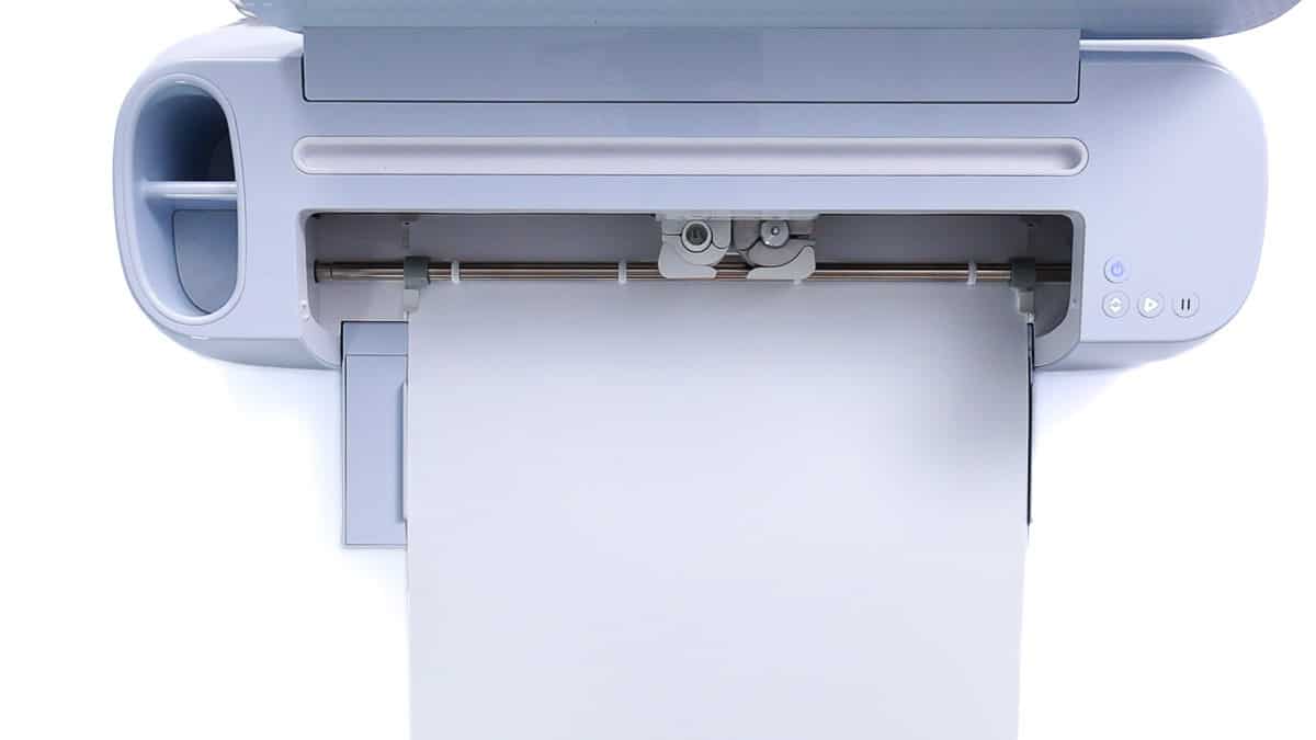 Cricut cutting machine loading a sheet of smart iron-on material directly into the machine without a cutting mat.