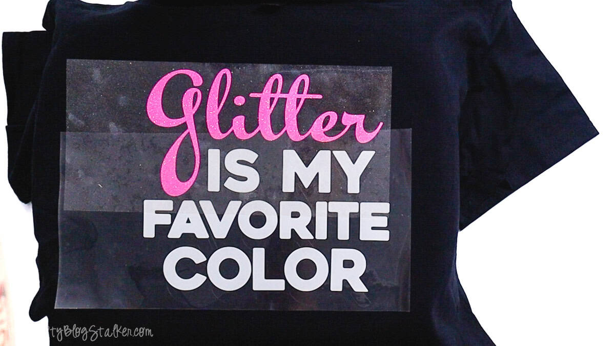Glitter Is My Favorite Color iron-on vinyl design positioned on a T-shirt under a carrier sheet, ready to be pressed with heat.