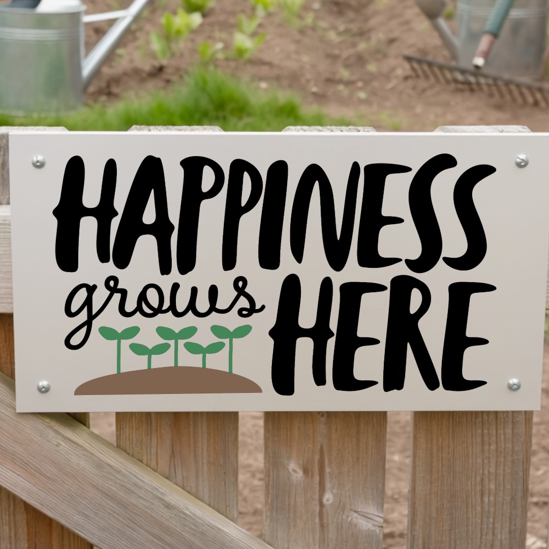 Garden sign mounted on a wooden fence that reads Happiness grows here with small sprout illustrations above a patch of soil.