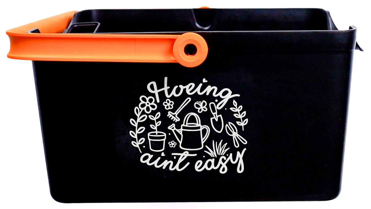 Black garden bucket with orange handle featuring a gardening-themed vinyl decal on the front with flowers, tools, and a watering can design.