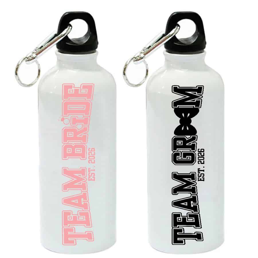 Two white metal water bottles with carabiner lids featuring Team Bride and Team Groom vinyl designs with est. 2026 text.
