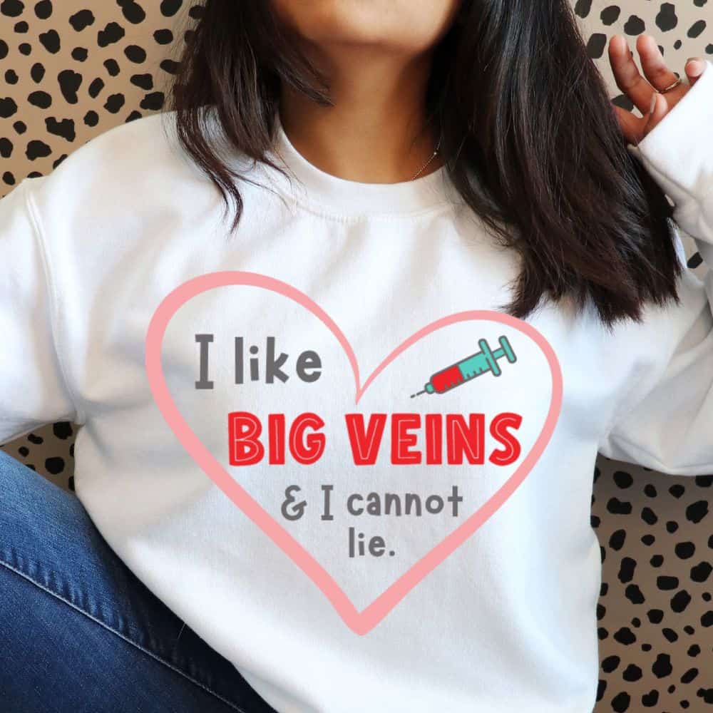 Person wearing a white sweatshirt with heart graphic and text 