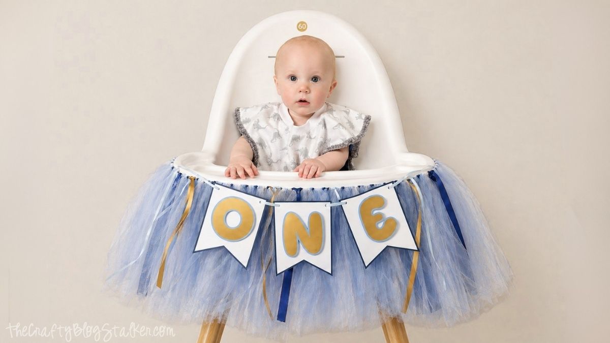 Baby sitting in a high chair with a tulle skirt and a 