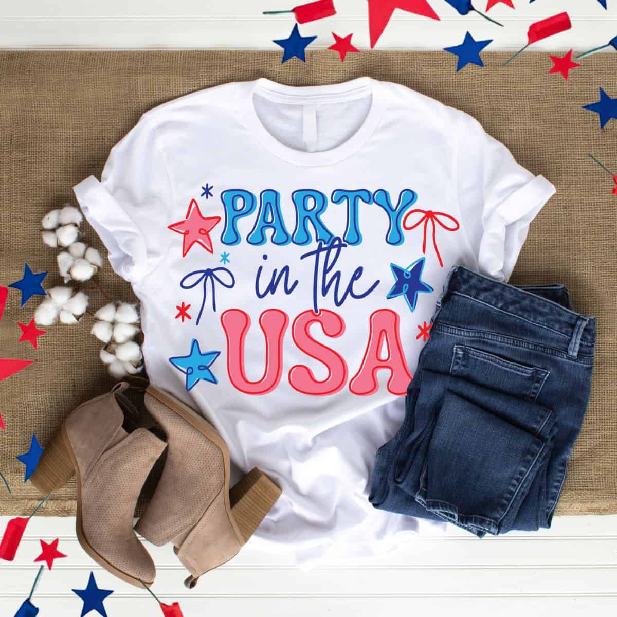 White Party in the USA graphic T-shirt styled with blue jeans, tan ankle boots, and patriotic red and blue star decorations.