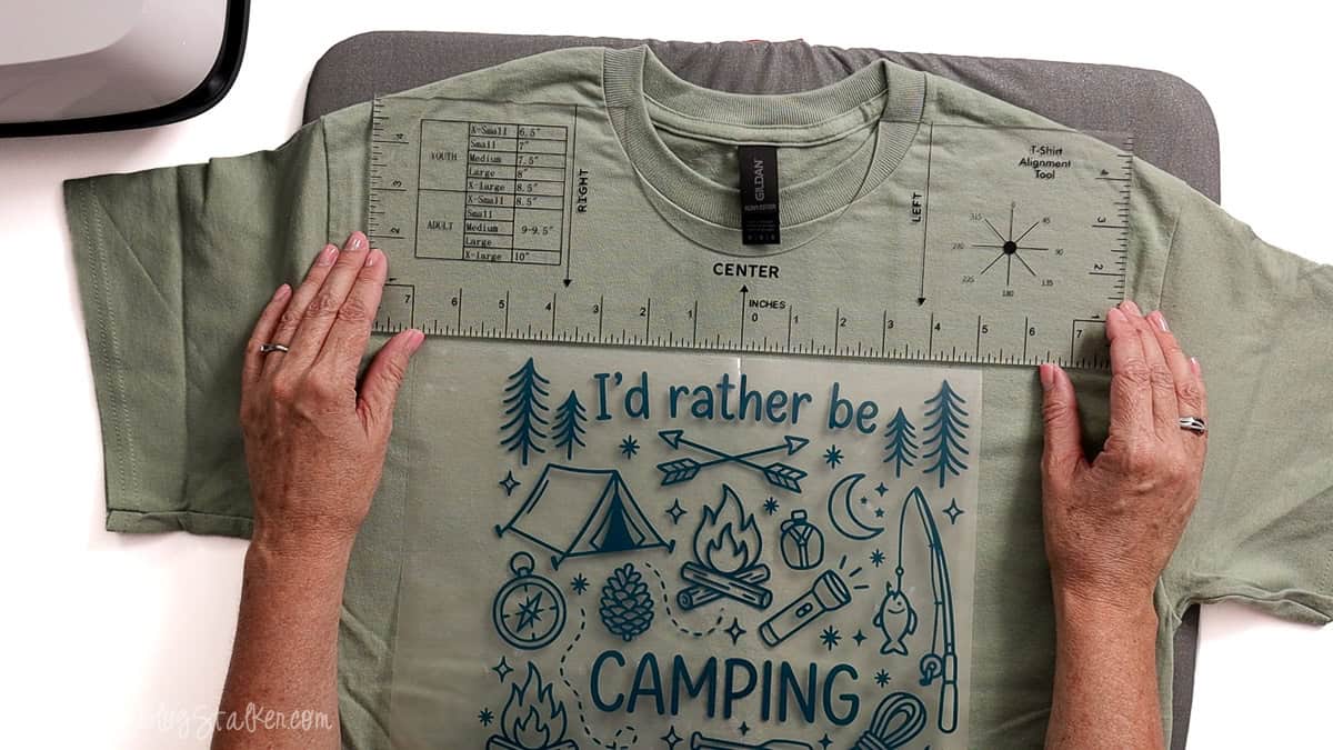 Hands using a T-shirt alignment ruler to position an