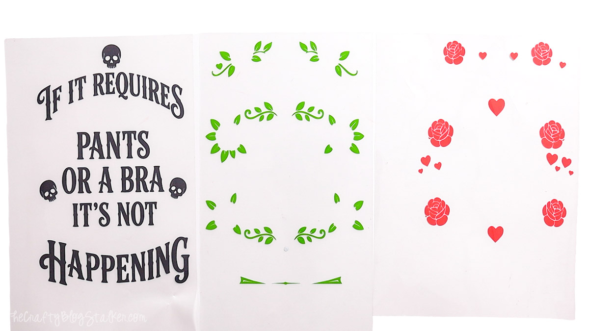 Three heat transfer vinyl carrier sheets display separate black, green, and red layers for a multicolor wood sign design before application.