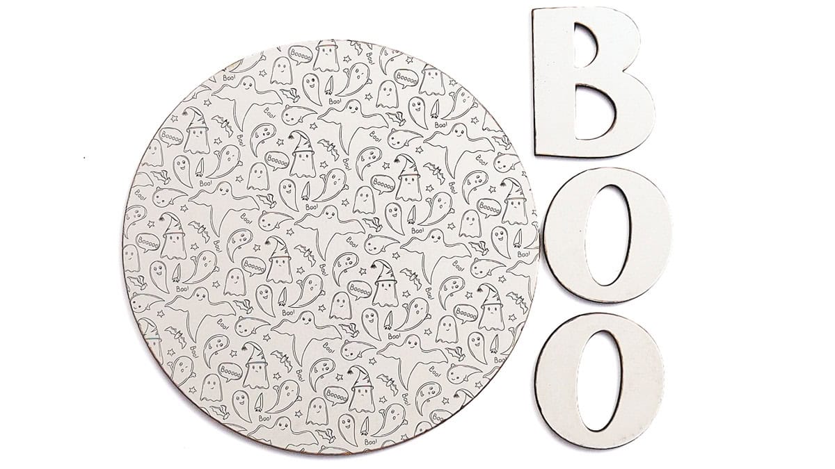 Round wooden Halloween sign engraved with a ghost pattern beside separate wooden B, O, and O letters ready to assemble.