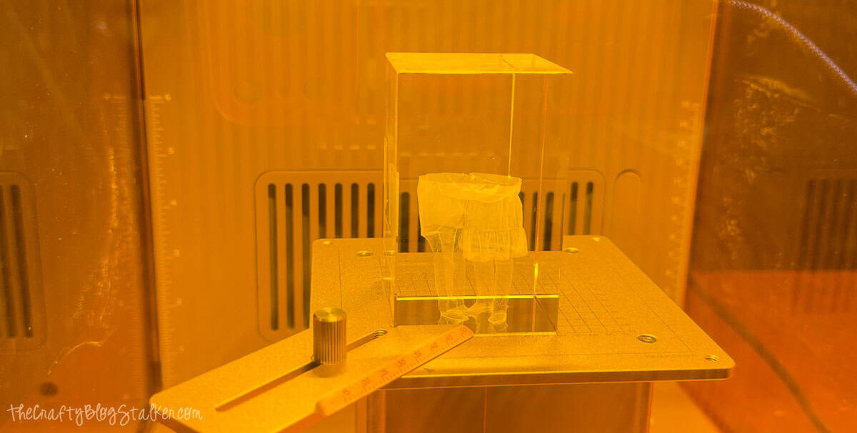 Crystal block secured in the xTool F2 Ultra jig during the 3D inner engraving process, with the engraved family image visible inside the crystal.