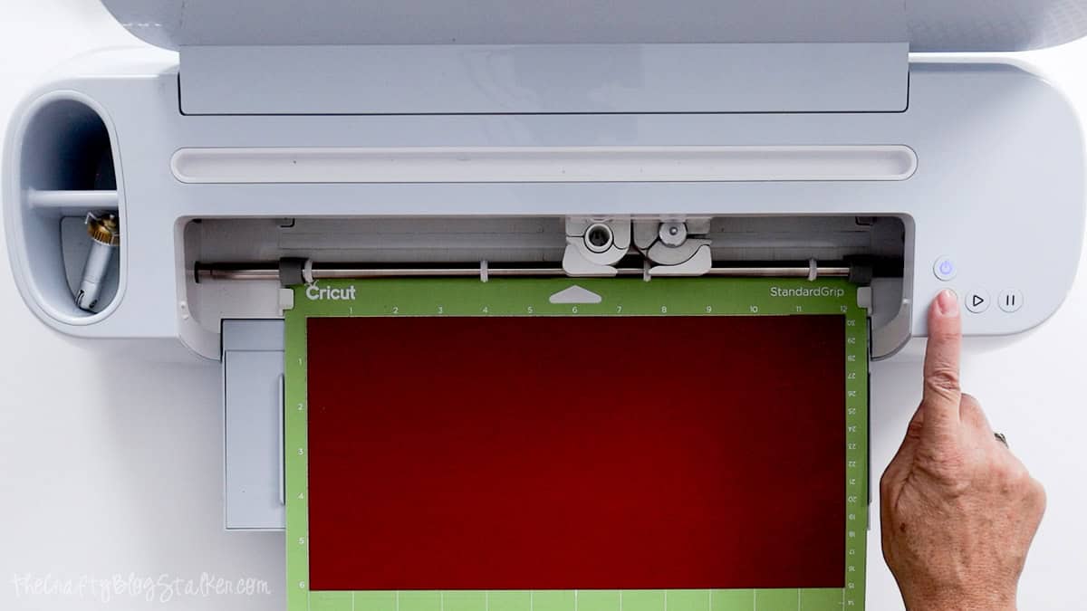 Cricut cutting machine with red cardstock on a green StandardGrip mat, ready to cut pieces for a handmade thank you card.