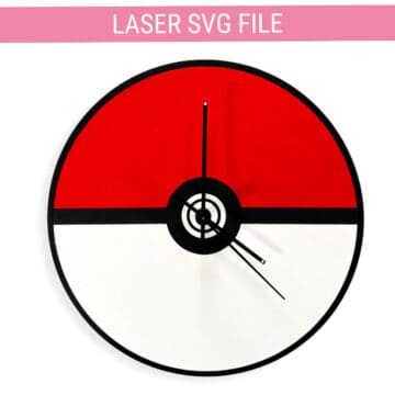 Round wall clock designed like a Poké Ball, with a red top half, white bottom half, black center circle, and black clock hands.