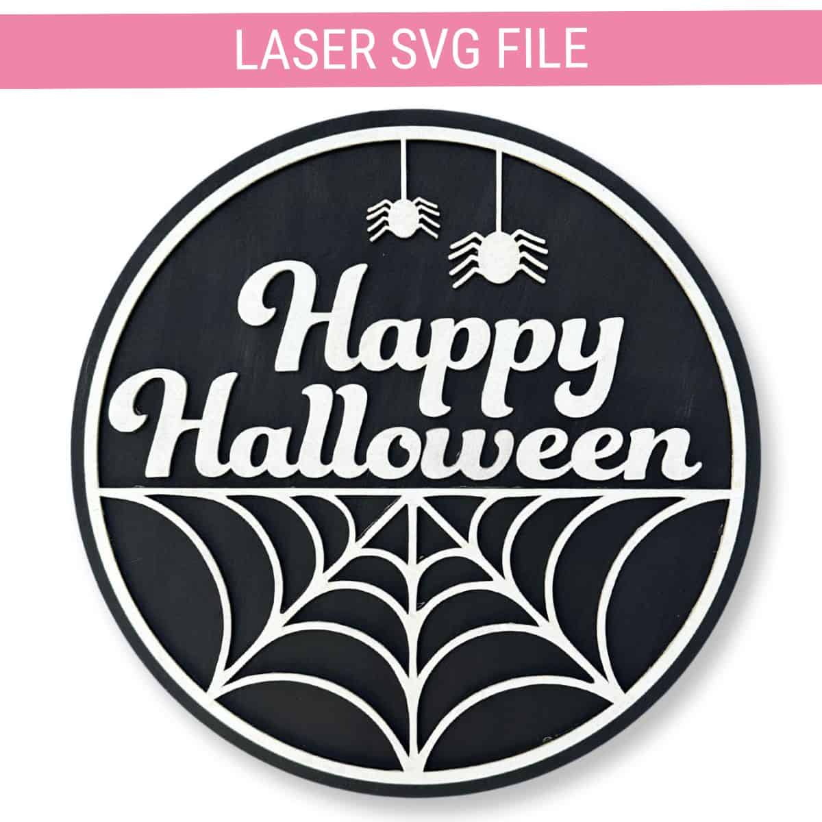 Round black Halloween door hanger with white text reading "Happy Halloween," a spiderweb design, and two hanging spiders at the top.