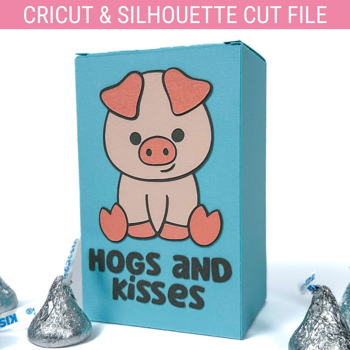 Blue paper treat box with a pig design and the words "Hogs and Kisses," displayed with silver foil-wrapped Hershey’s Kisses around it.