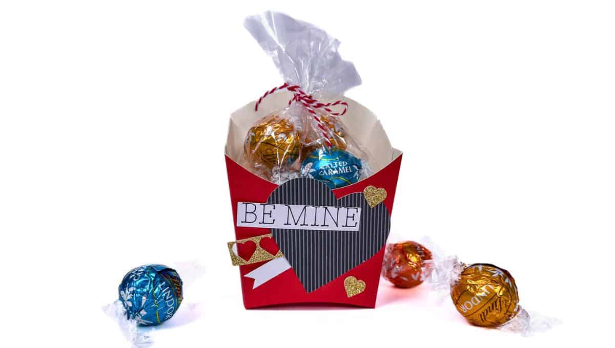 A digital template for crafting a fry box, including purple box cutouts, a pink heart, a pink band with white hearts, and the text "Be Mine" for decoration.