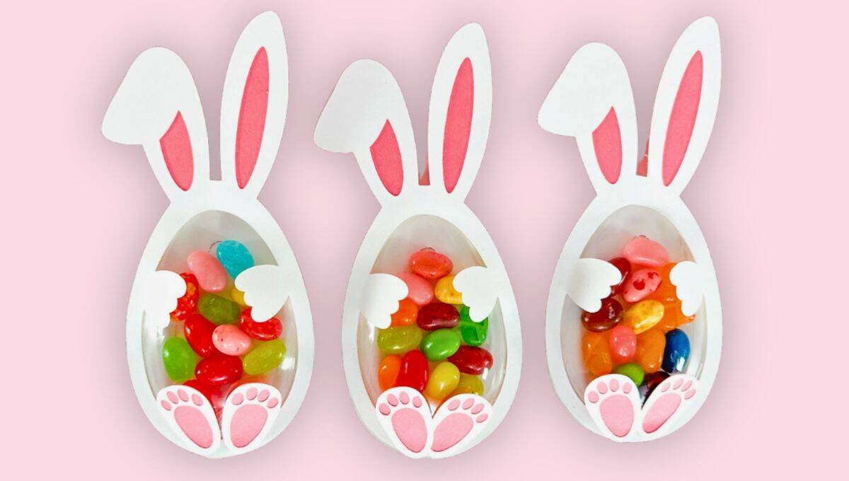 Three Easter bunny treat holders made from paper, each filled with colorful jelly beans. The design features bunny ears, paws, and a clear treat window.