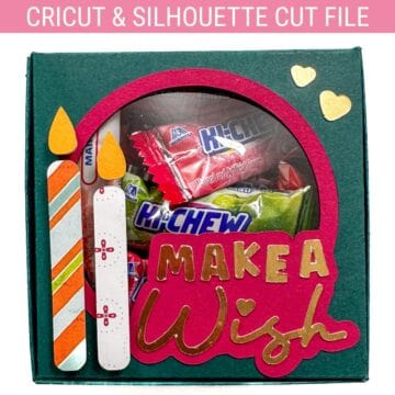 DIY birthday gift box made with Cricut, featuring a window filled with candy, two paper candles, and a pink cutout reading “Make a Wish.”