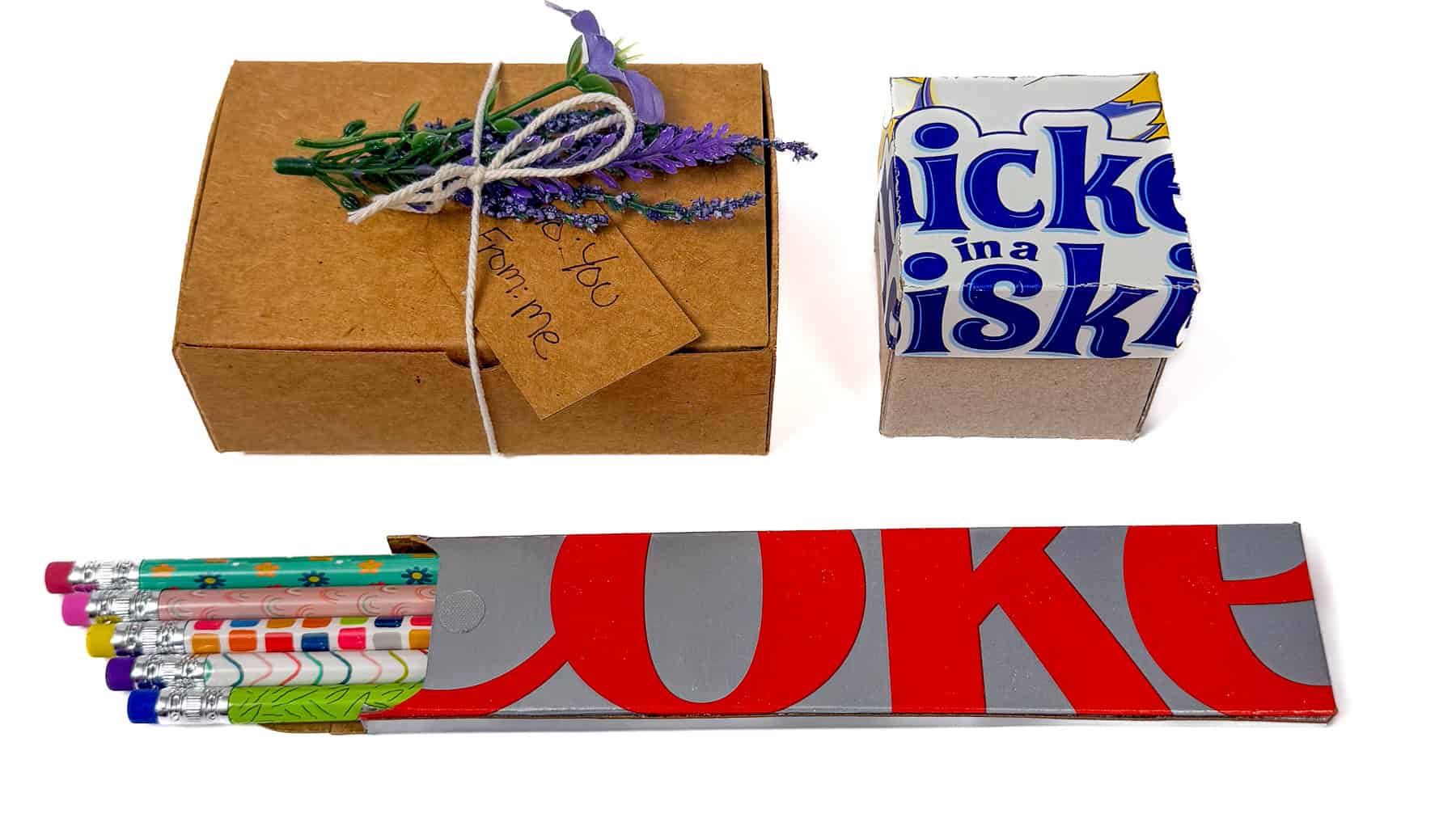 Upcycled cardboard gift boxes made from food packaging, including a decorated gift box, small carton box, and pencil holder.