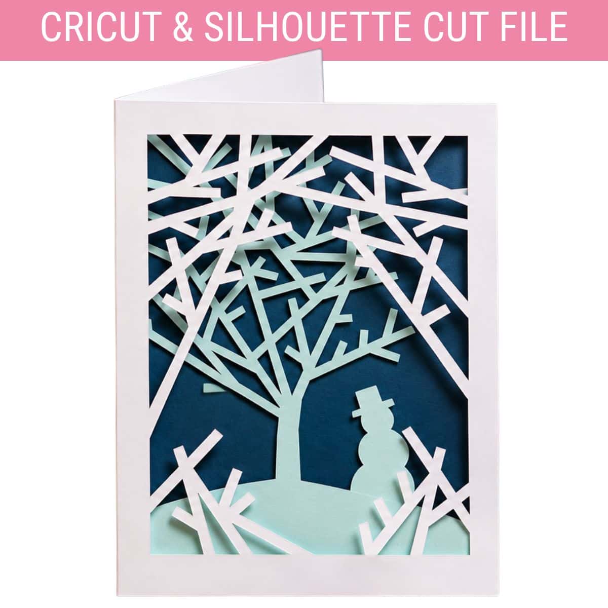 Layered Snowy Woods Christmas card with white paper trees, a mint green snowman, and a dark blue background, designed for Cricut and Silhouette.